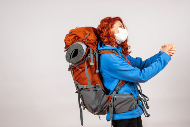肖像戴着面具背着背包的女游客的正面图快乐旅行女游客