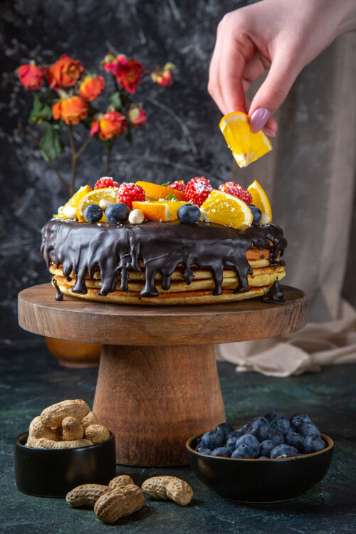 黑的正面是美味的巧克力蛋糕和新鲜水果在黑暗的墙上食物新鲜的糖