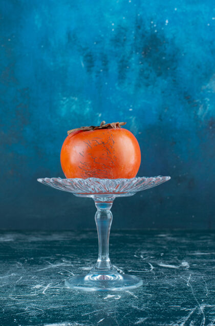 料理美味的熟柿子放在玻璃盘子里玻璃成熟新鲜