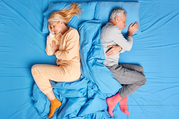 浪漫上图为已婚老两口熟睡在舒适的床上 背靠着对方 穿着柔软的睡衣 在辛苦工作后好好休息 享受舒适的氛围人们的睡眠理念老年视图舒适