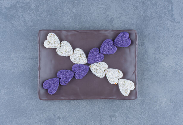 风味紫色和白色的饼干在黑板上 在大理石背景上美味美味五颜六色