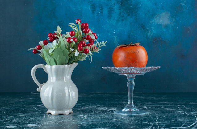 成熟美味的熟柿子放在玻璃盘子里 还有花瓶玻璃柿子农业
