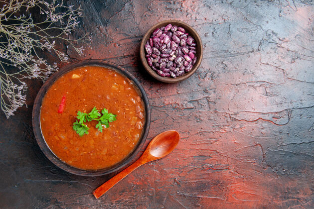 盘子在一个棕色碗里的经典西红柿汤的水平视图混合颜色的桌子上的豆子和勺子蔬菜水平午餐