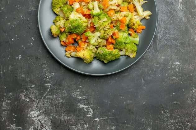 概述概述健康餐与花椰菜和胡萝卜在一个黑色的盘子在灰色的桌子上炒锅厨房用具午餐