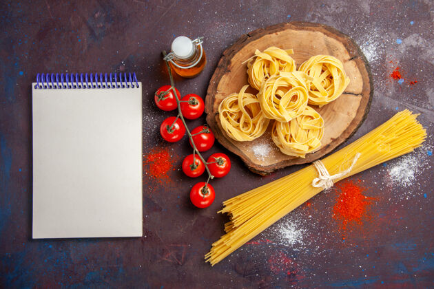 意大利面顶视图新鲜的红色西红柿与生意大利面食在黑暗的背景上生沙拉面食膳食浪漫面包