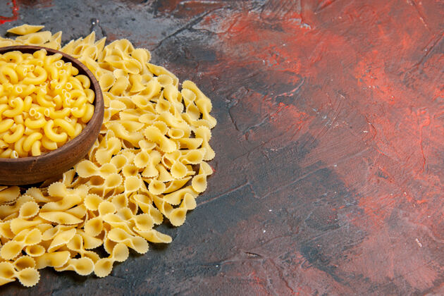 意大利面蝴蝶生面放在一个棕色的碗里 放在五颜六色的桌子上封闭食物生的