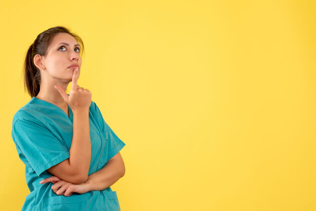 一前视图穿着医用衬衫的女医生在黄色背景上思考女医生衬衫医疗