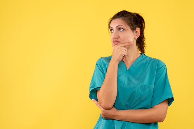 人前视图穿着医用衬衫的女医生在黄色背景上思考黄色视图健康