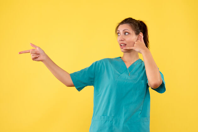 衬衫前视图黄色背景上穿着医用衬衫的女医生人女医生前面
