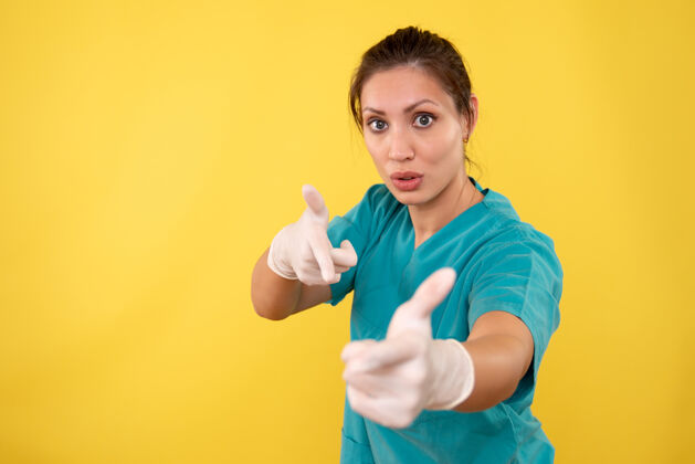 视图前视图黄色背景上戴着医用手套的女医生成人病毒手套