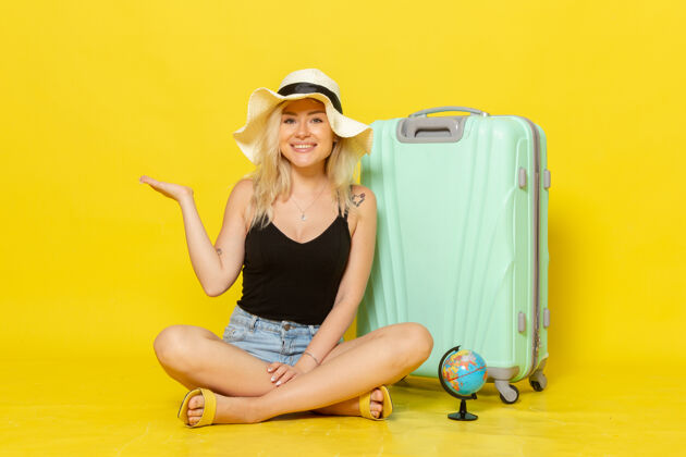 海正面图：年轻女子背着包坐在黄墙上旅行度假海上旅行晒太阳成年人运动健身