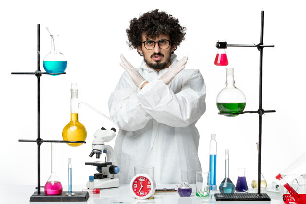 西装正面图身穿白色特别套装的年轻男性科学家在白墙上展示禁止标志科学科维德实验室大流行化学科学家医学化学