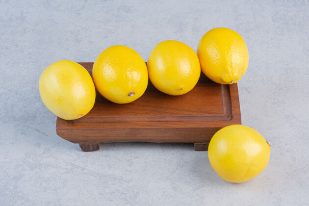 柠檬一组新鲜的柠檬放在一块古老的木板上柠檬水桌子楔