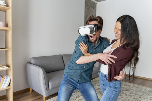 女人男人在家里玩虚拟现实耳机旁边的女人水平虚拟现实耳机增强现实