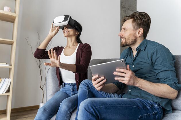 虚拟现实男人和女人在家玩虚拟现实耳机和平板电脑的乐趣增强现实乐趣虚拟现实