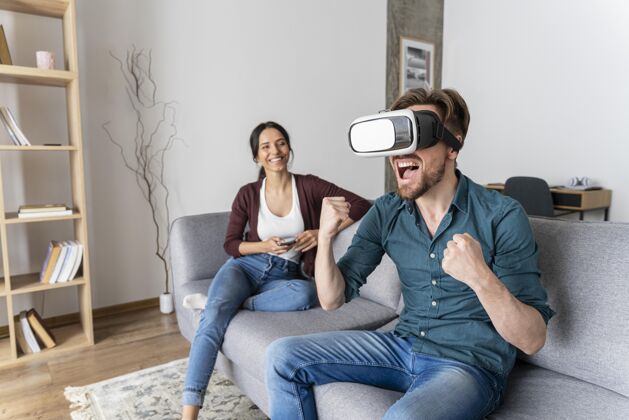 增强现实坐在沙发上玩虚拟现实耳机的男人男人虚拟现实耳机女人