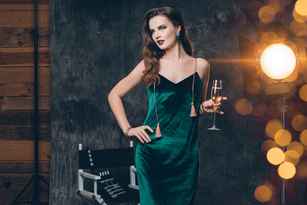 活动年轻时尚性感的女人在电影院后台 用一杯香槟庆祝华丽奢华女人