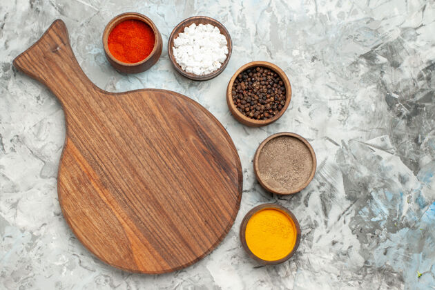 调味品半张健康的木制砧板 不同的香料放在白色的桌子上烹饪砧板香料
