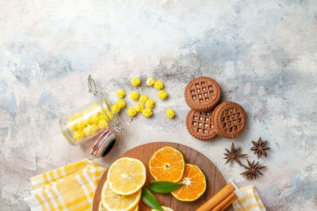肉桂半张柠檬片肉桂酸橙放在木砧板上 饼干放在白桌子上一半晚餐柠檬