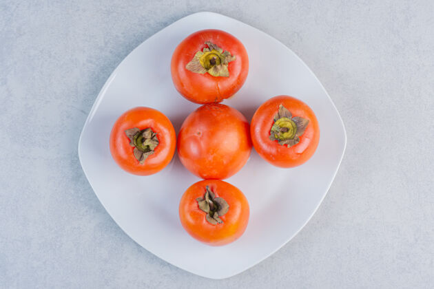 套餐成熟的橙色柿子水果特写照片白色盘子上的新鲜柿子食物自然特写