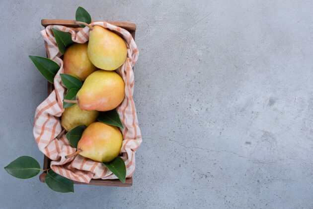 配料梨子 树叶和毛巾放在大理石背景的木篮里风味美味美味