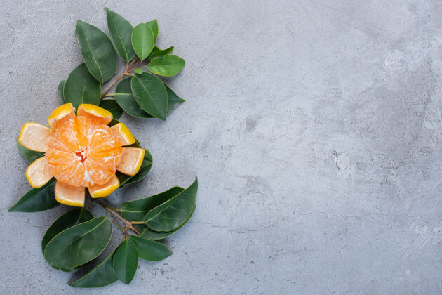 天然剥皮的橘子和大理石背景上的装饰叶饮食爽口健康