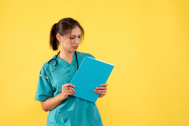 病毒正面图黄色背景下穿着医用衬衫的女医生拿着分析女医生视图专业