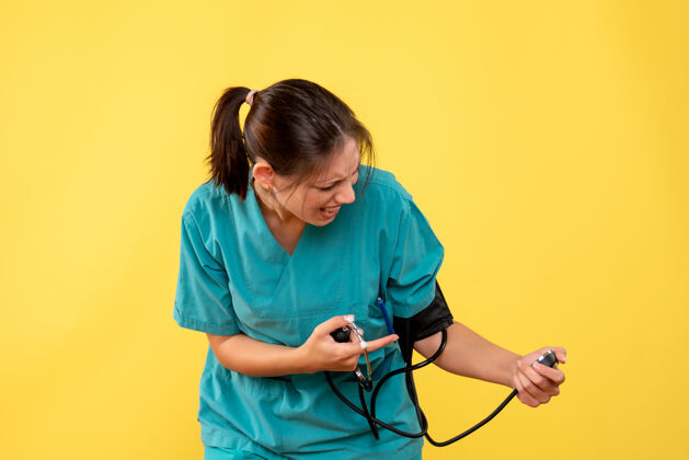 衬衫前视图穿着医用衬衫的女医生正在检查黄色背景上的压力前面视图听诊器