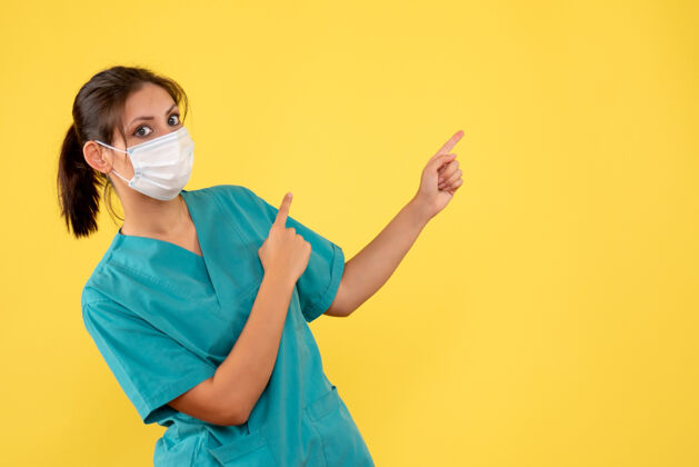 女医生前视图黄色背景上穿着医用衬衫和面罩的女医生面具医疗健康