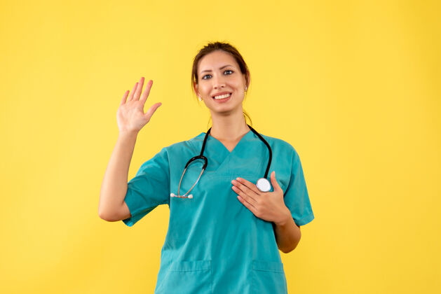 健康前视图黄色背景上穿着医用衬衫的女医生微笑衬衫黄色