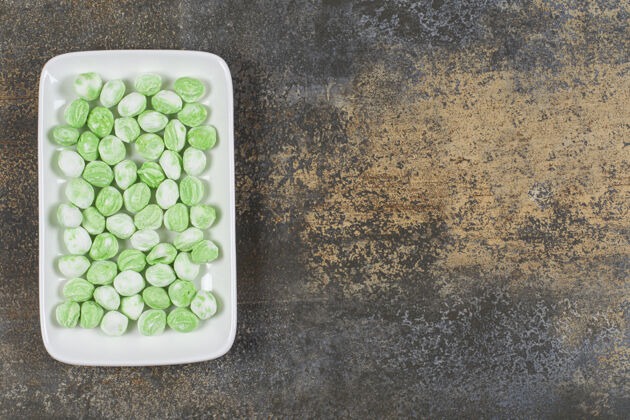 薄荷一堆绿色薄荷醇糖果放在白色盘子里薄荷邦邦香料