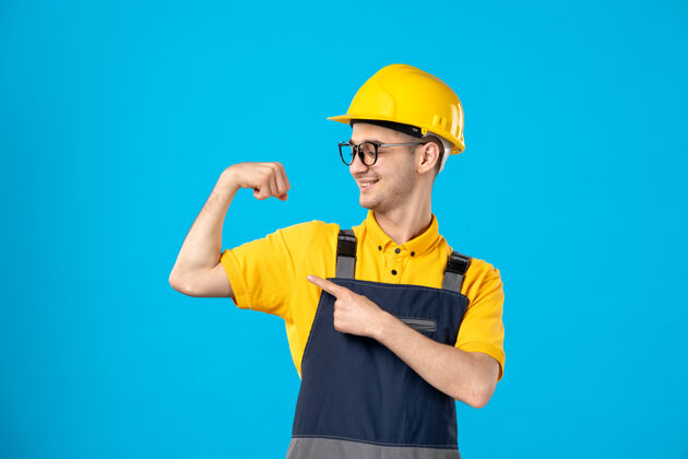 服务身穿黄色制服的男工人正对着蓝色微笑和弯腰头盔建筑工人杂工
