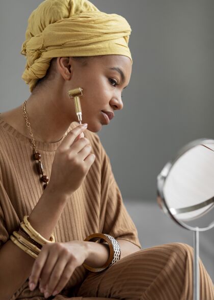 物体阿拉伯妇女使用面部按摩美容治疗镜子产品魅力