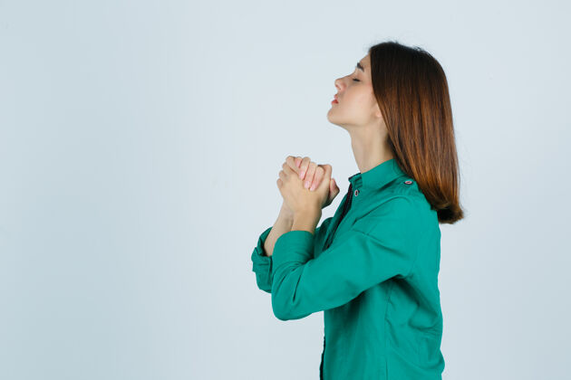 地平线身着绿色衬衫的年轻女性双手合十祈祷 充满希望前进手女孩