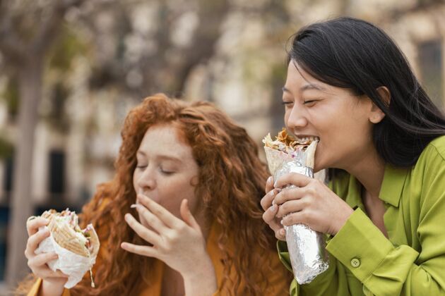 美味快乐的女人一起吃街头美食女人快餐午餐