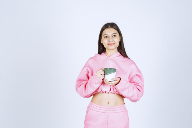 姿势穿着粉色睡衣的女孩拿着一个咖啡杯 感觉很开心员工摄影服装