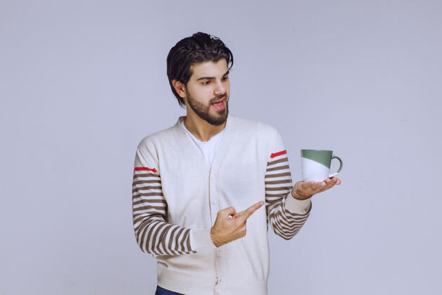 聪明一个穿着白衬衫的男人拿着一个咖啡杯指着它员工成人人类