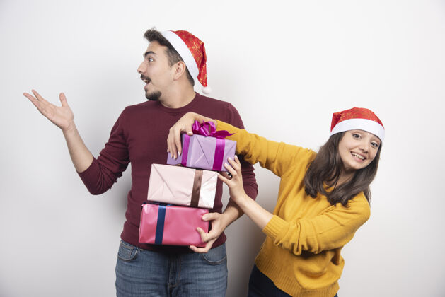 新的一对戴着圣诞老人帽子的幸福夫妻 圣诞礼物和新年礼物肖像盒子圣诞老人