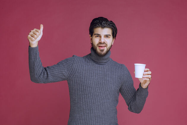 员工男人拿着一个一次性咖啡杯 做着享受的手势人人类姿势