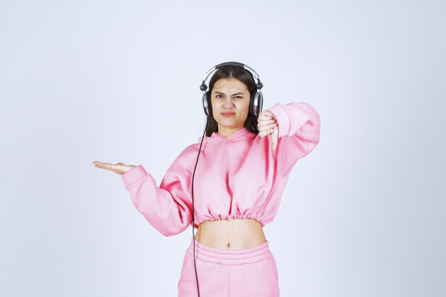 姿势穿着粉色睡衣的女孩在听耳机 不喜欢音乐高质量的照片照片工作人员模特