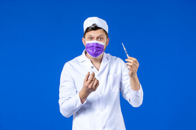 病毒男医生的前视图 穿着医疗服 戴着蓝色的注射和疫苗面罩实验服疫苗外套