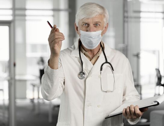 实验室戴着医用面罩的医生在检查他的笔记实验室医疗护理