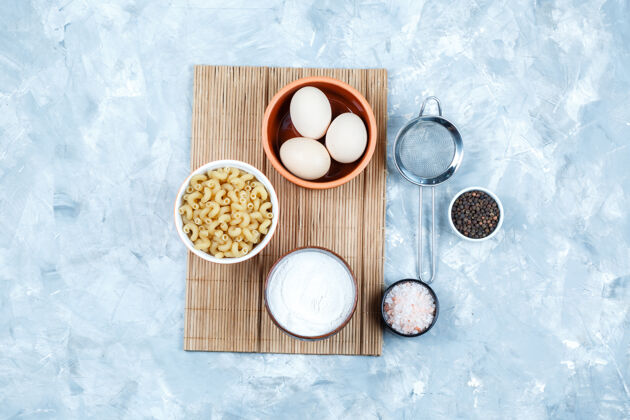 新鲜一些卡瓦塔皮意大利面 配鸡蛋 酸奶 香料 粗灰色碗中的滤网和砧板背景 顶视图番茄咕噜咕噜美味