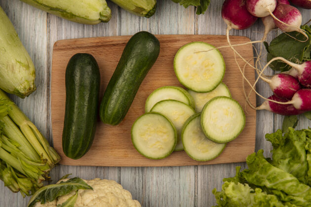配料顶视图低热量黄瓜与萝卜 西葫芦和芹菜隔离在一个灰色的木制厨房板上素食芹菜食物