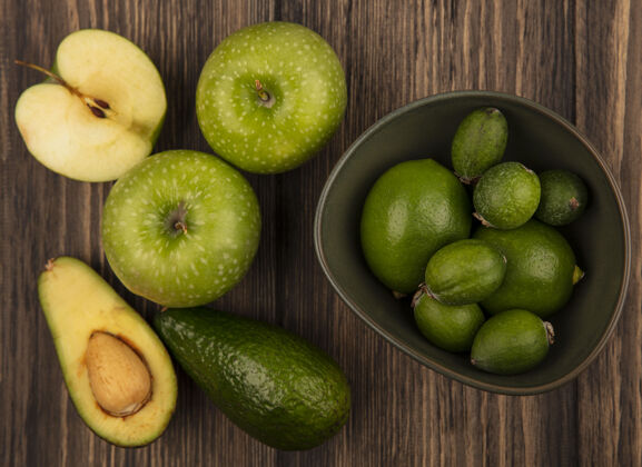 酸橙在一个碗上放着新鲜的酸橙 绿色的苹果和鳄梨孤立在一个木制的表面上饮食苹果美味