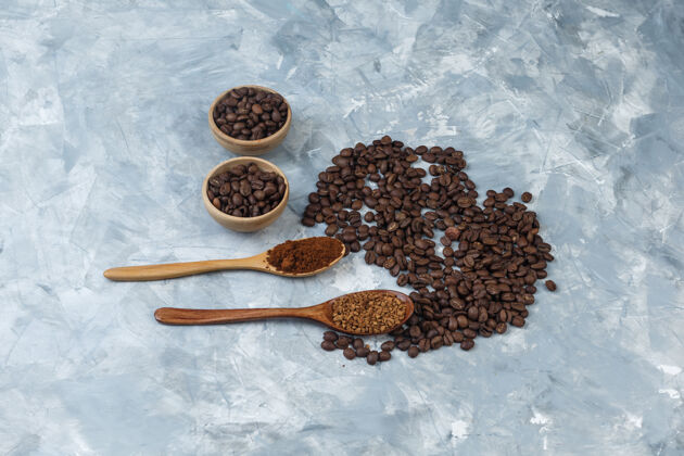 休息在浅蓝色大理石背景上 高角度观看碗中的咖啡豆 速溶咖啡和木勺中的咖啡粉水平时间食物面粉