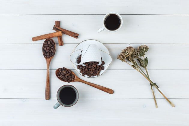自然咖啡杯里有咖啡豆 肉桂棒 干草 木制背景上的顶视图芳香咖啡