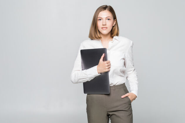 笔记本电脑成功的女商人在白墙上拿着一台笔记本电脑朋友行政便携式