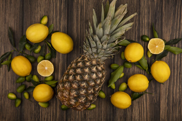 美味顶视图的水果 如菠萝柠檬和金盏花孤立在一个木制表面饮食健康农业