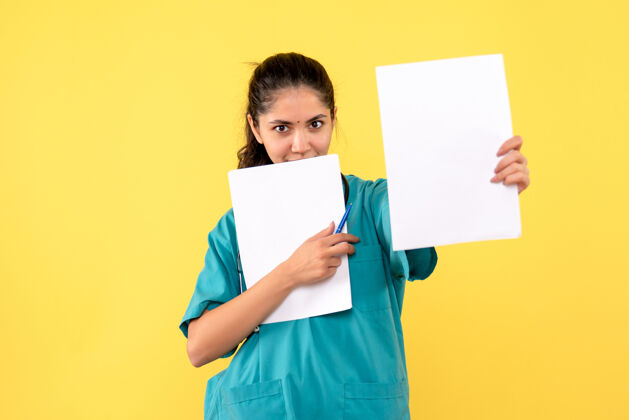电脑正面图微笑的漂亮女医生拿着黄色背景的文件办公室男性背景